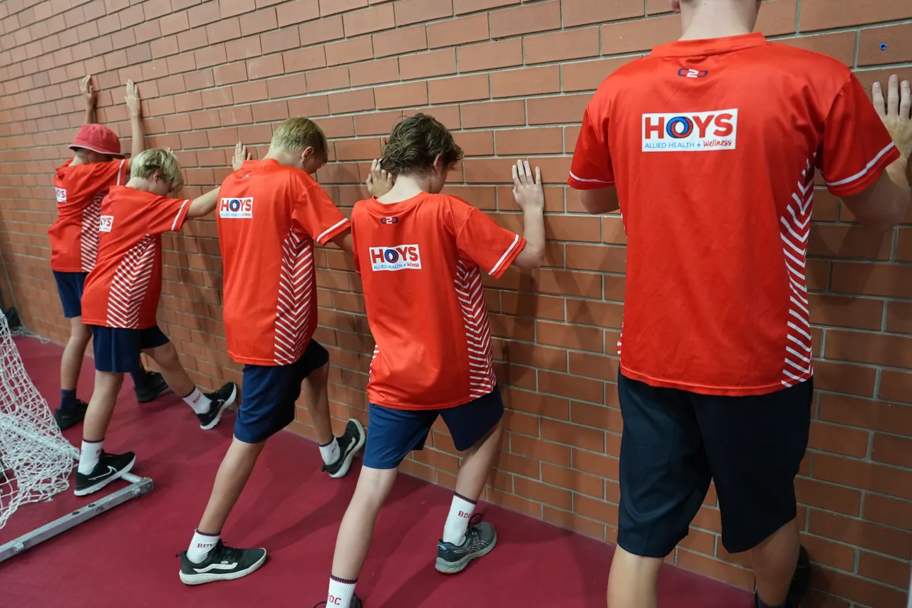 Sports performance coach providing movement assessment and training guidance to an athlete.