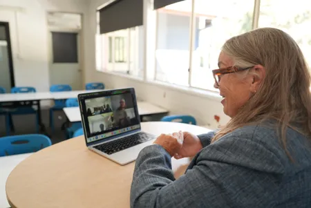 Teacher supporting students through online learning in NSW