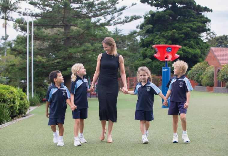 Primary school students walking with school principal.