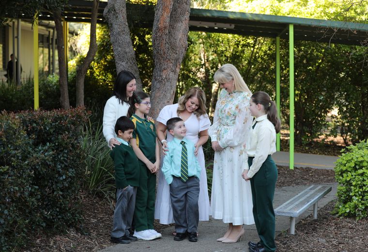 Primary school students and families speaking to teacher.