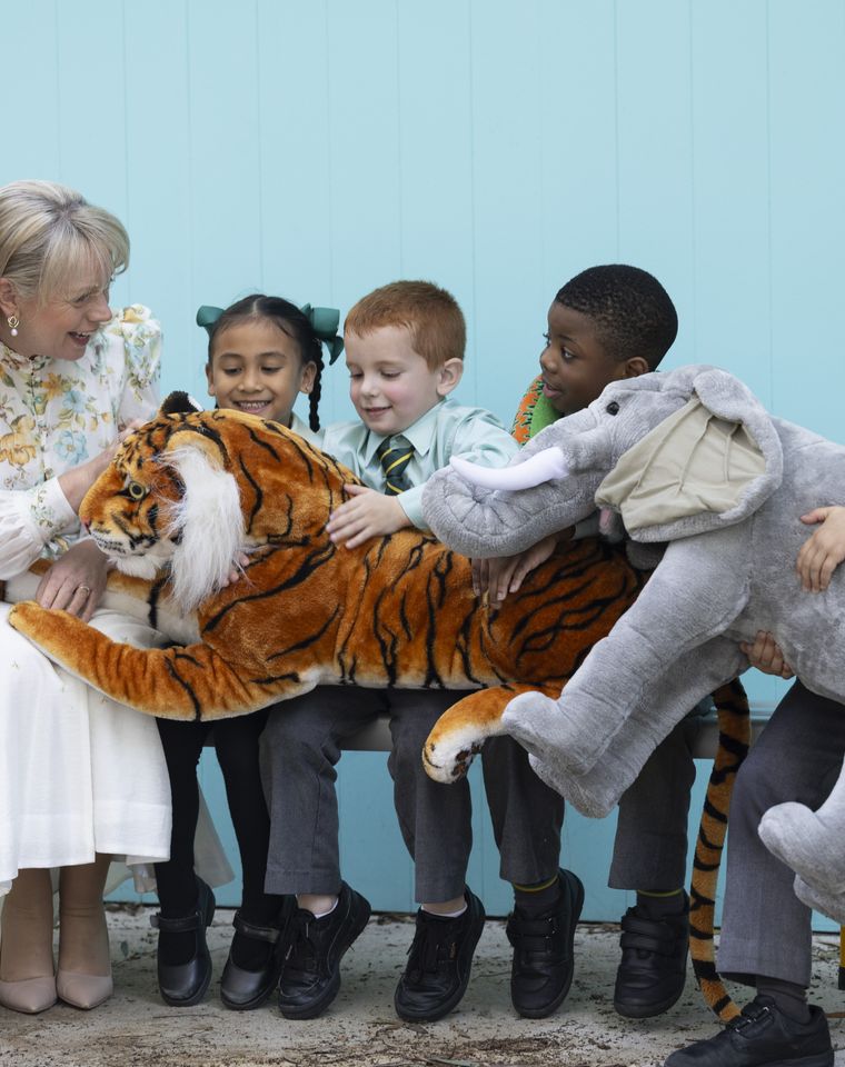 Primary school students with teacher and plush toys.