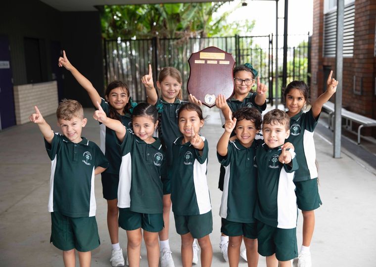 Group of primary school students pointing the number one.