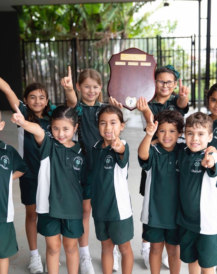 Group of primary school students pointing the number one.