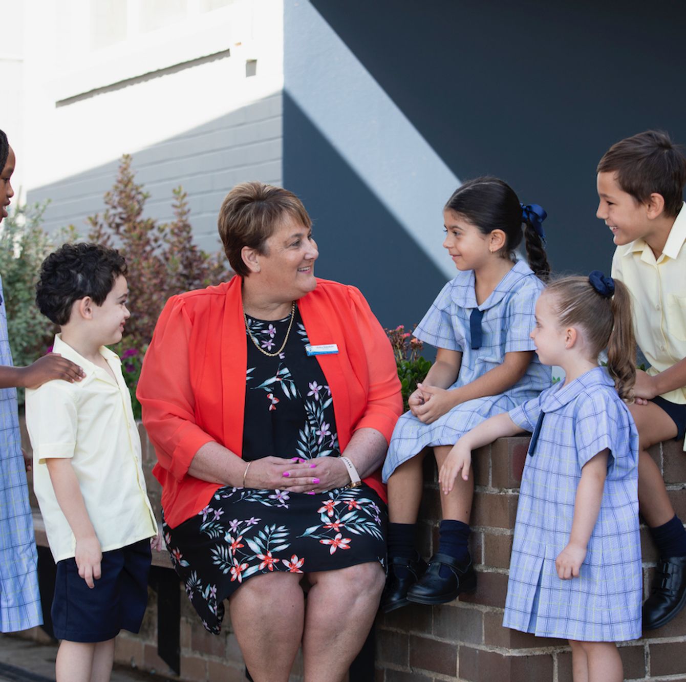 Primary school principal talking with five students.