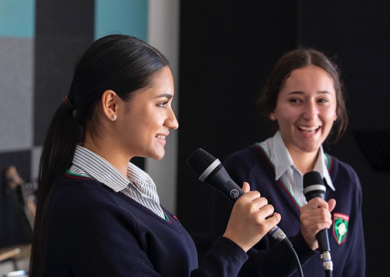 High school students speaking into microphone.