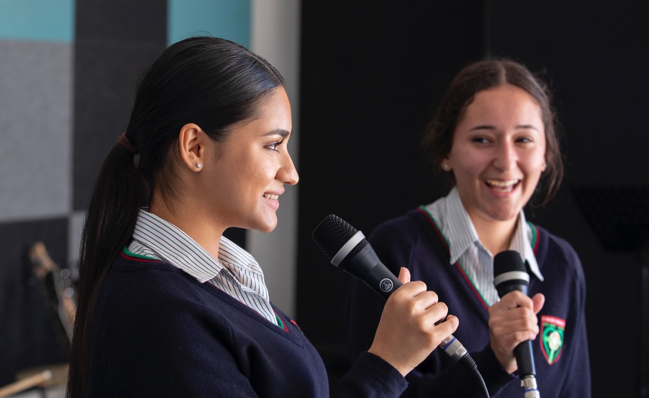 High school students speaking into microphone.