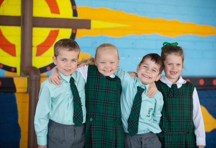 Group of students standing together with arms around each other.