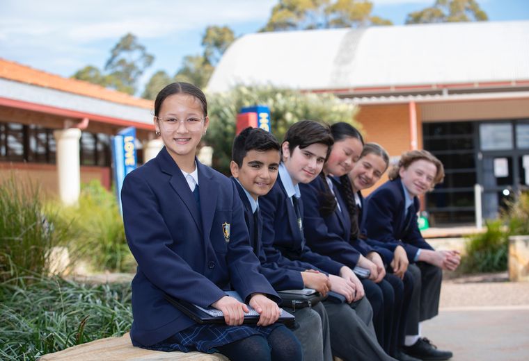 Six junior high school students sitting on bench and looking at camera.