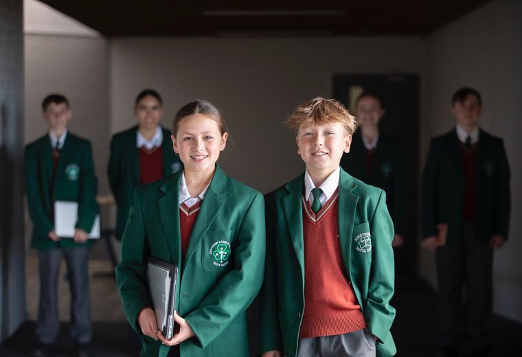 High school students standing together and smiling at camera.