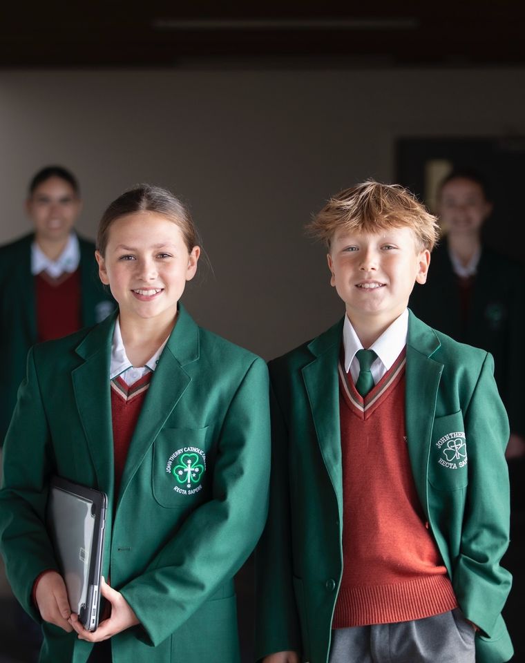 High school students standing together and smiling at camera.