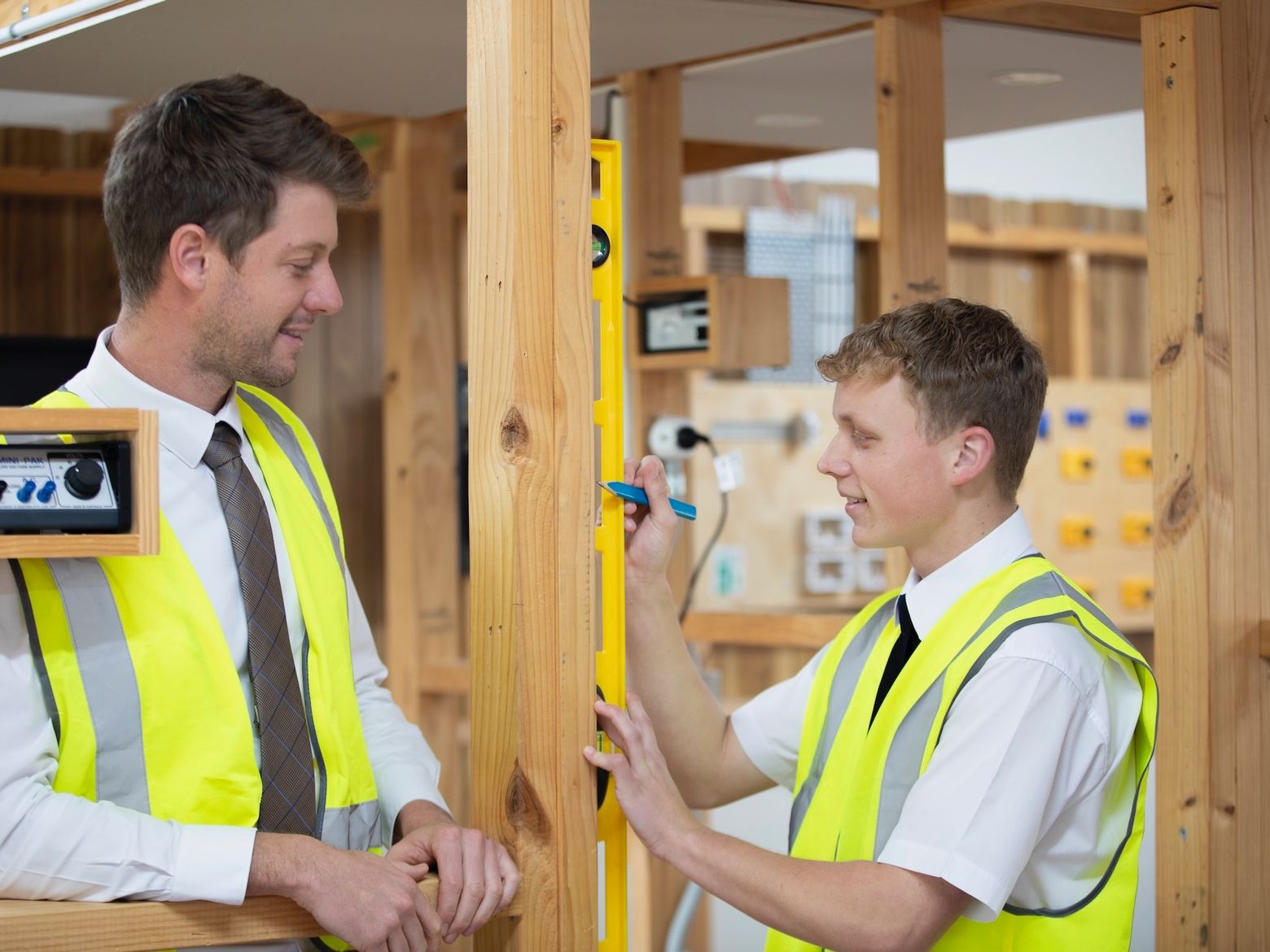 High school student doing woodwork with teacher.