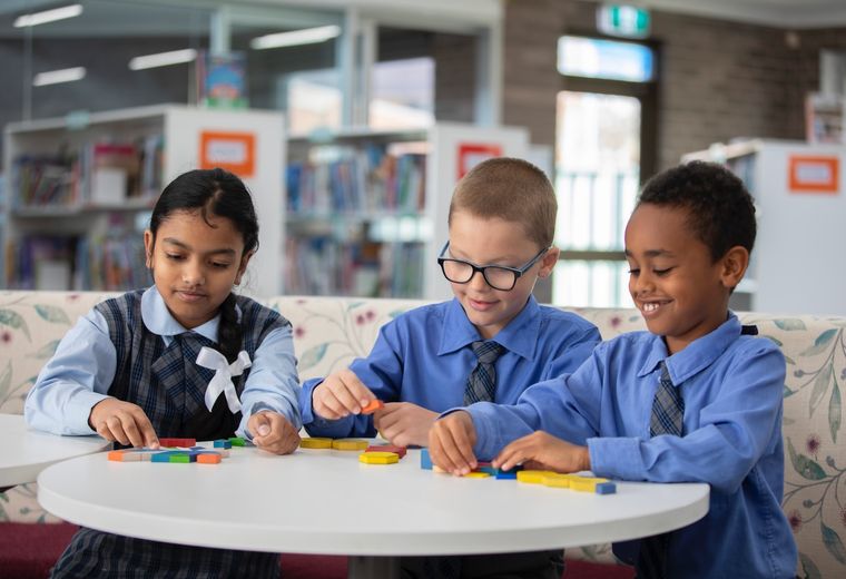 Primary school students doing schoolwork on desk.