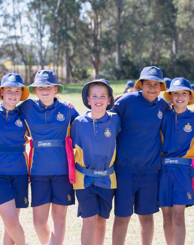 Group of primary school students standing together in sports uniform.