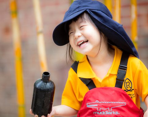 A kindergarten student smiling whilst playing outdoors in the Early Learning Centre at Ruyton Girls' School