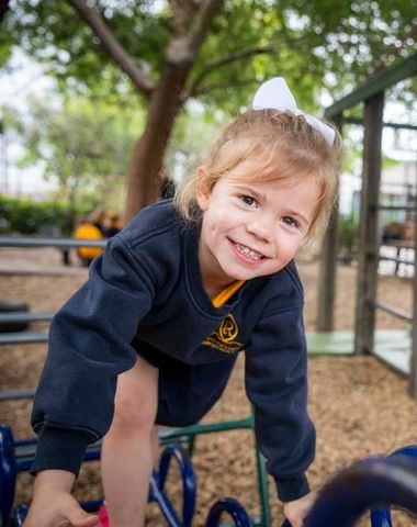 A kindergarten student climbing outdoor play equipment in the Early Learning Centre at Ruyton Girls' School