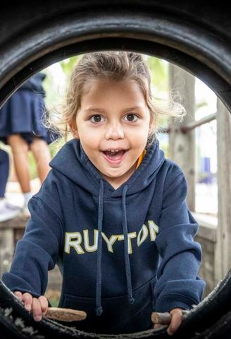 A kindergarten student climbing through outdoor play equipment in the Early Learning Centre at Ruyton Girls' School
