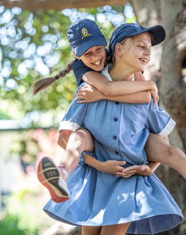 Two students playing under the historic Moreton Bay Fig Tree at Ruyton Girls' School.