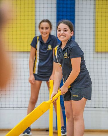 Ruyton students smiling as they play cricket.