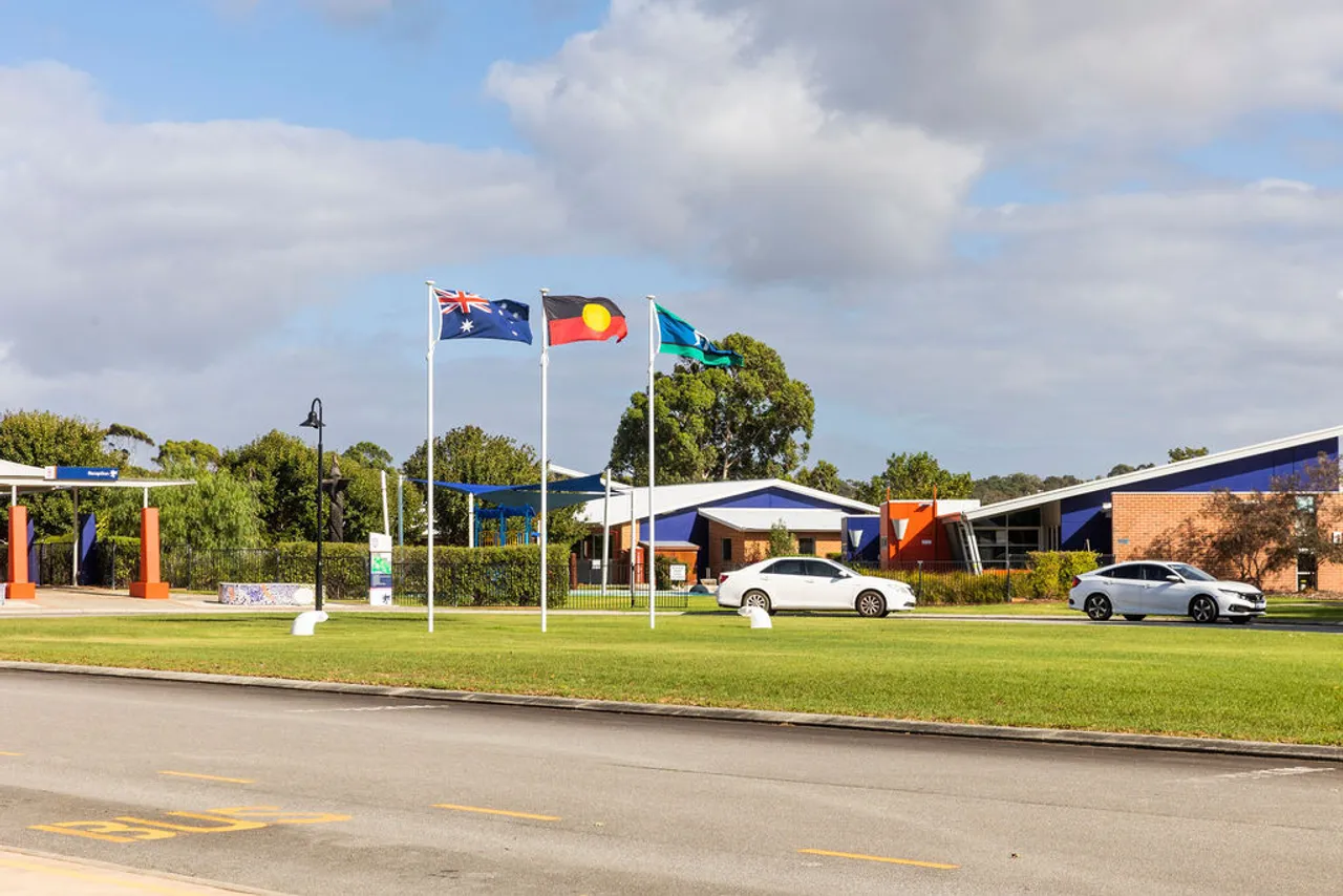 School entrance with Australian, Aboriginal & Torres Strait Island flags raised.