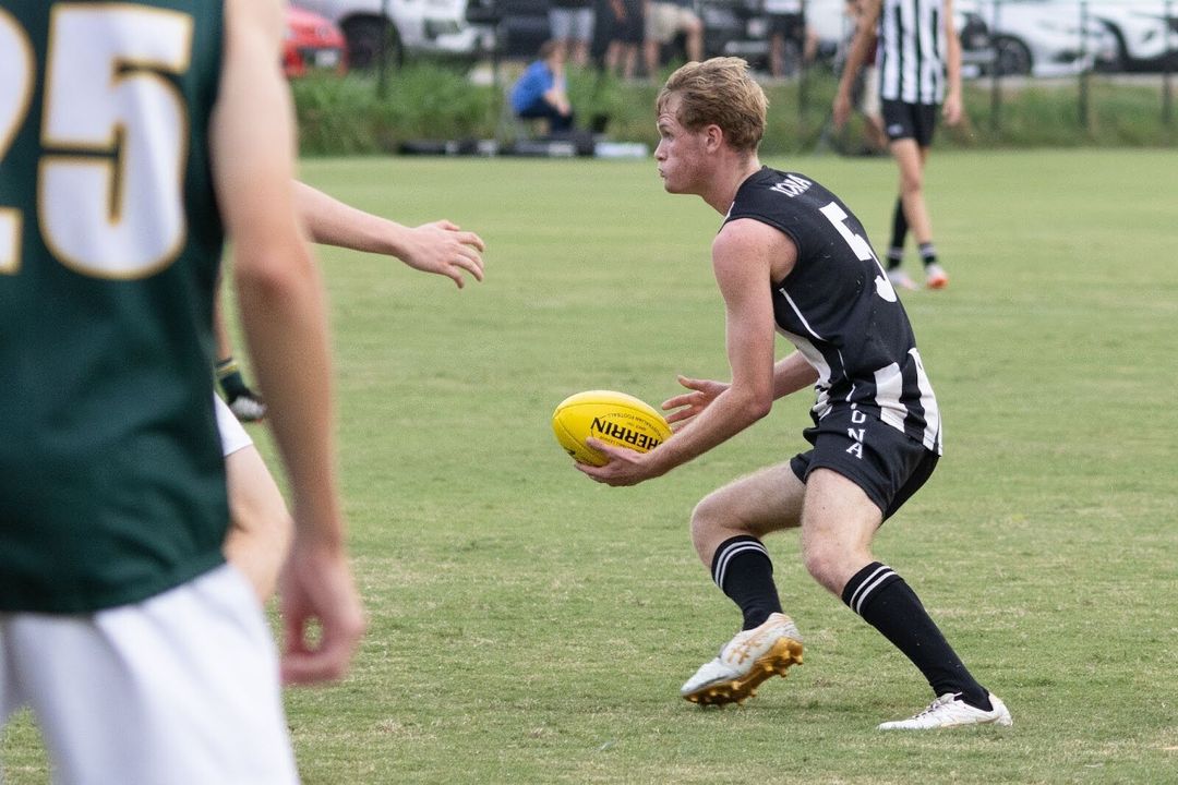 An Iona student playing AFL about to pass the ball