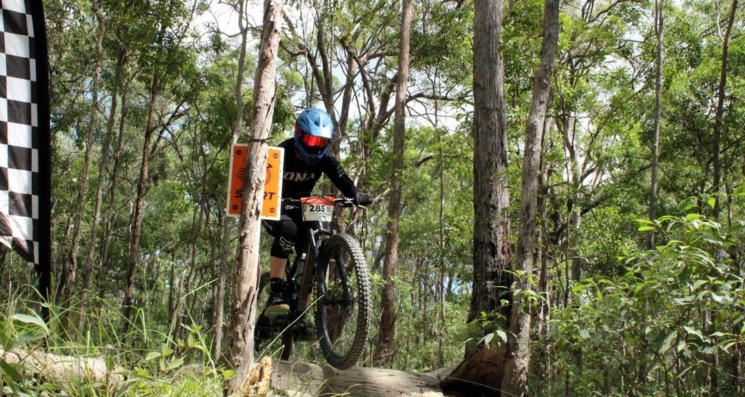 Iona student riding through a bush track