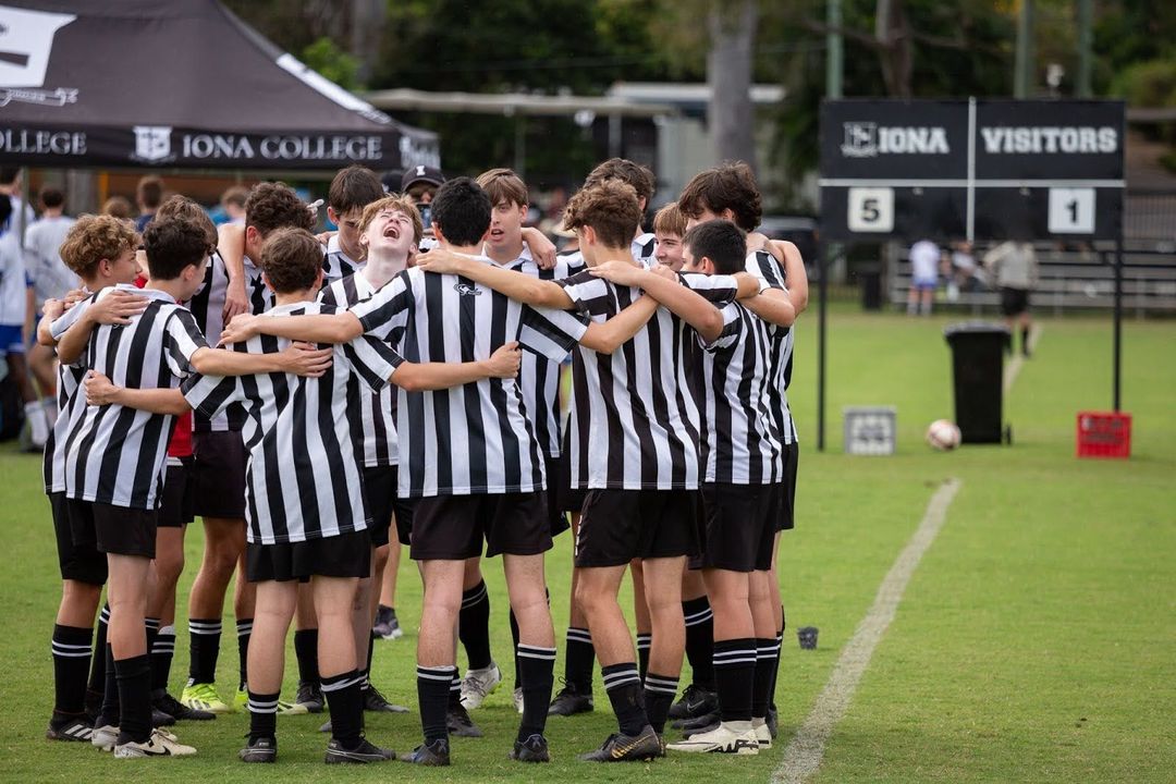 The Iona soccer team huddles together chanting before a match