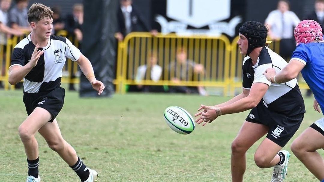 Two Iona rugby players passing the ball