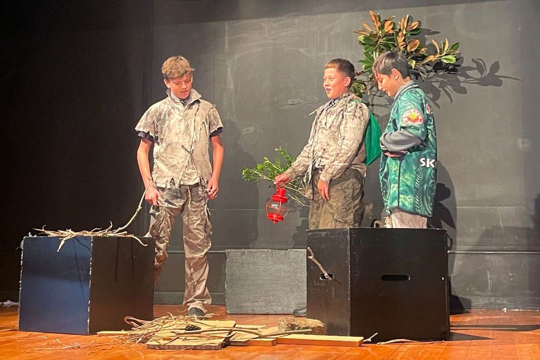 3 students performing on stage