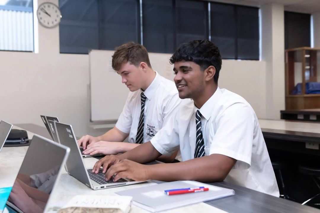Two senior students working on laptop in the science lab