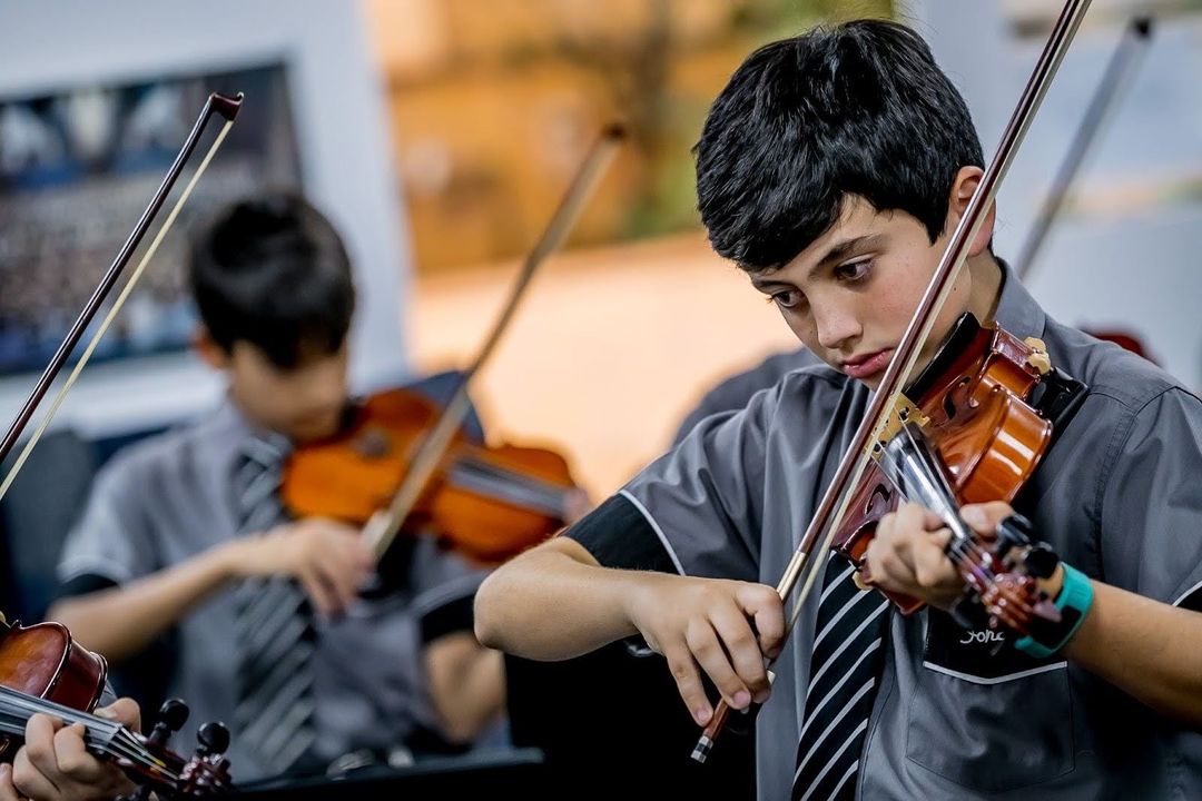Students playing violin together