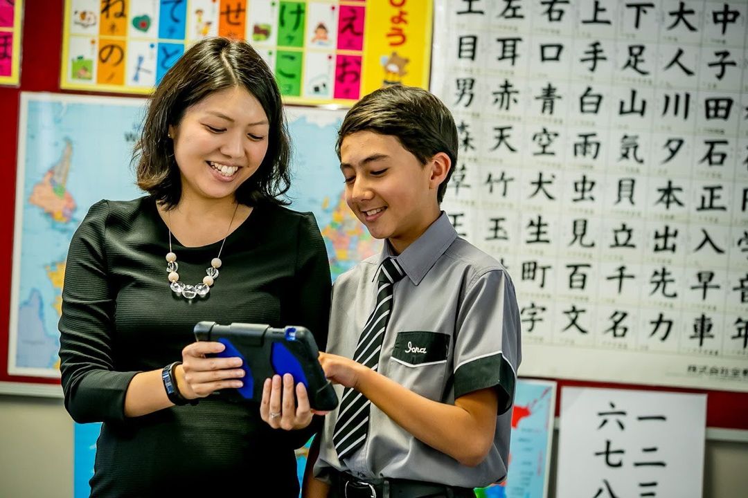 Teach and student reading a screen together in a Japanese classroom
