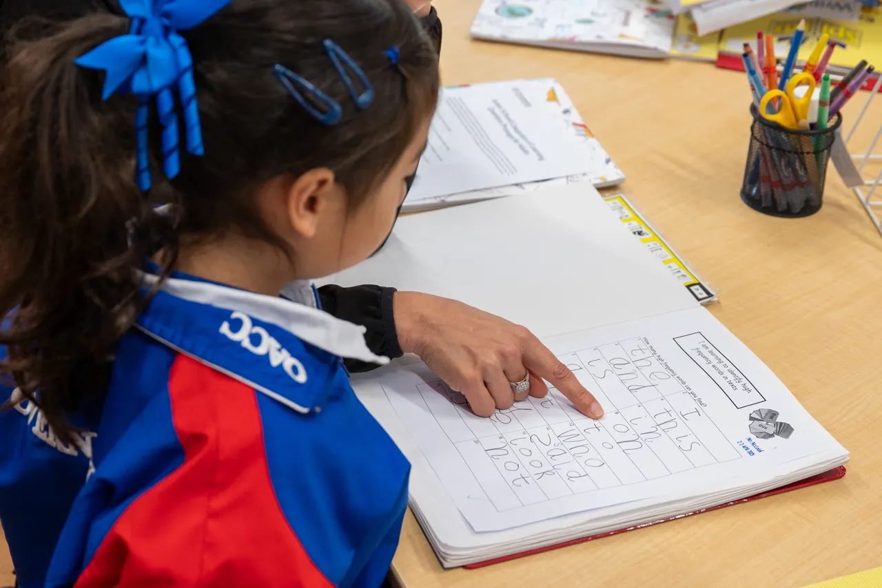 Lower primary school aged student proudly showing her school work to her mother, a guest at Overnewton's Junior School during their Celebration of Learning event.