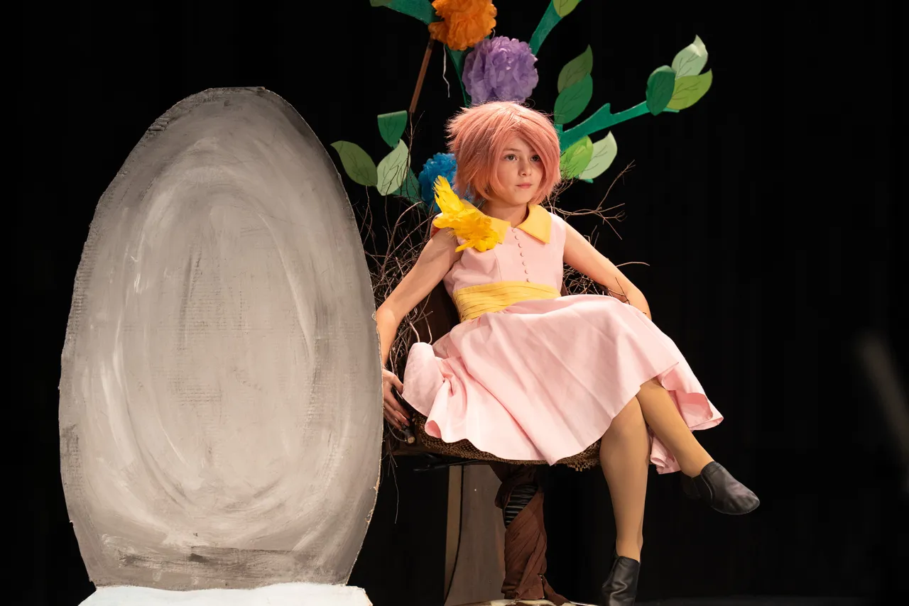 Upper primary school aged student in bright costume and wig captured mid-performance during the Middle School Year 5 & 6 Musical Season 1 production of Seussical KIDS.