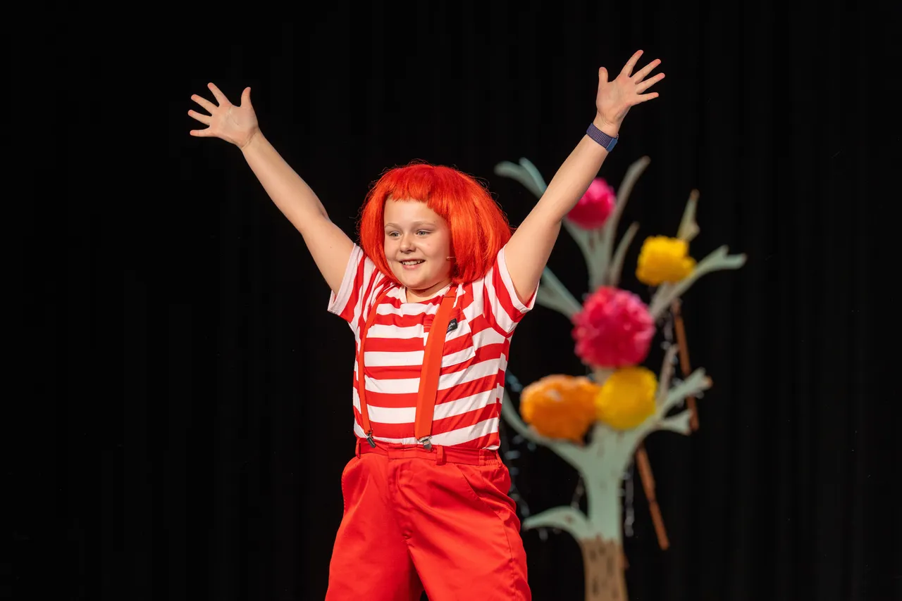 Upper primary school aged student in bright costume and wig captured mid-performance during the Middle School Year 5 & 6 Musical Season 1 production of Seussical KIDS.