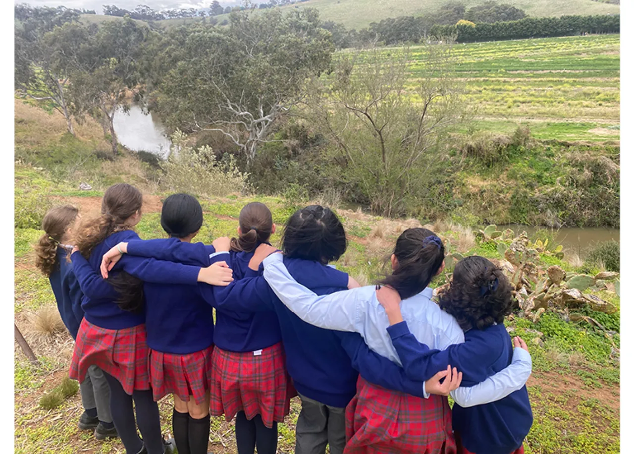 Students with interlinked arms looking over the Maribyrnong River Valley at Overnewton’s Yirramboi Campus, Keilor.