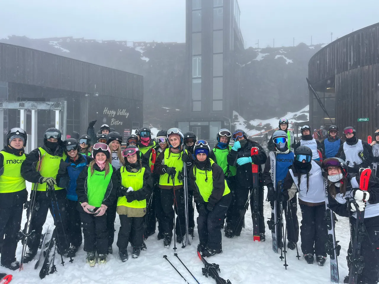 Large group of upper secondary school aged students wearing ski gear and goggles on a foggy ski field in Queenstown, New Zealand, during a Year 11 Co Curricular educational travel program.