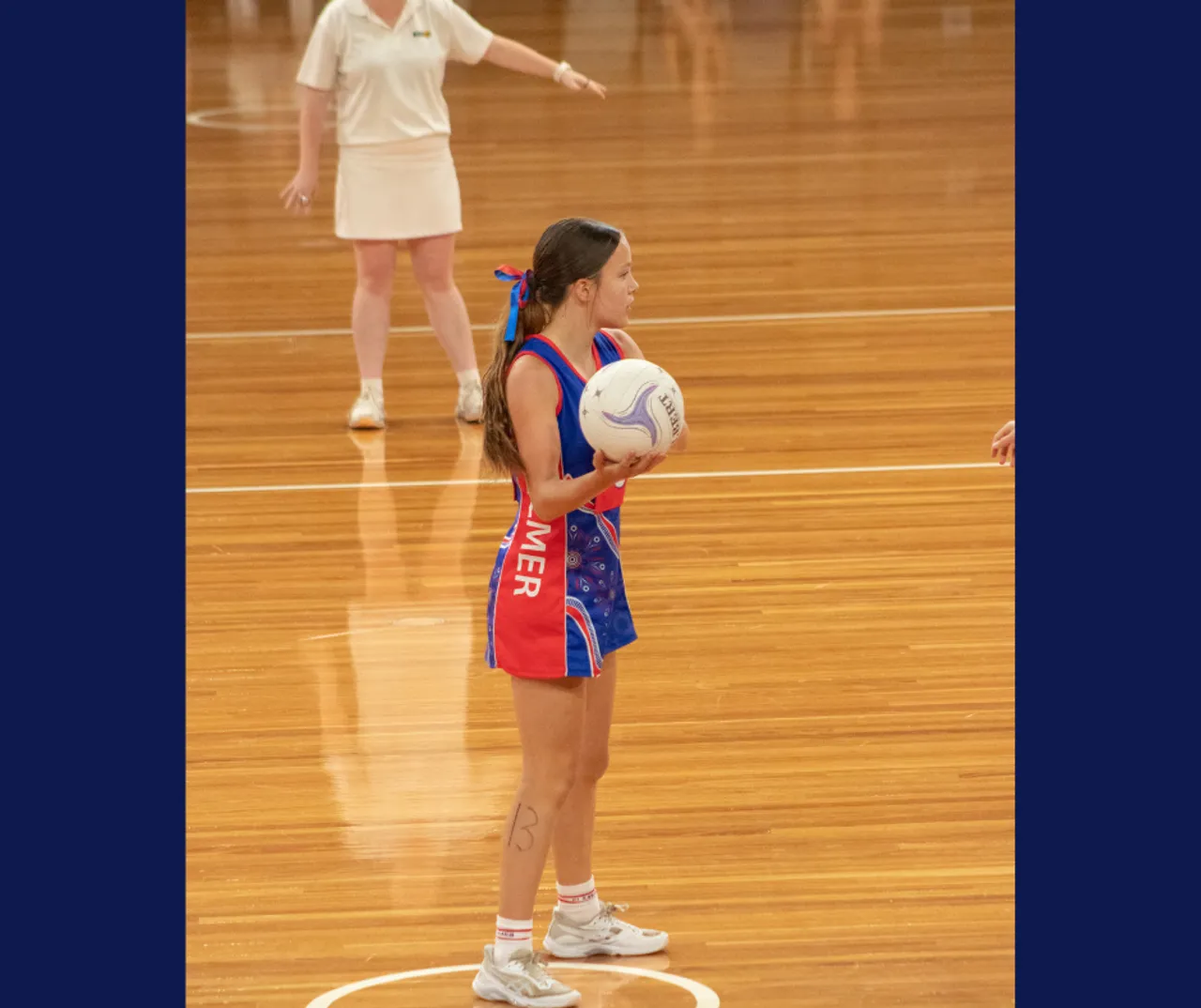 Action shot of Overnewton student Grace playing in the Under 15s Netball competition at the State Netball Titles.