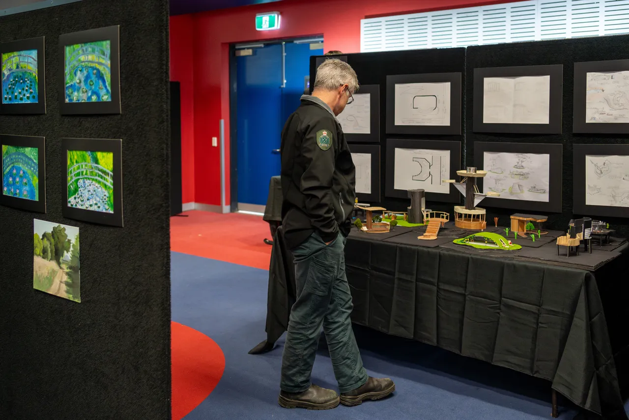 A guest at Overnewton's Annual Visual Arts & Technologies Exhibition viewing 3D models crafted by Senior School Visual Arts & Technologies students.