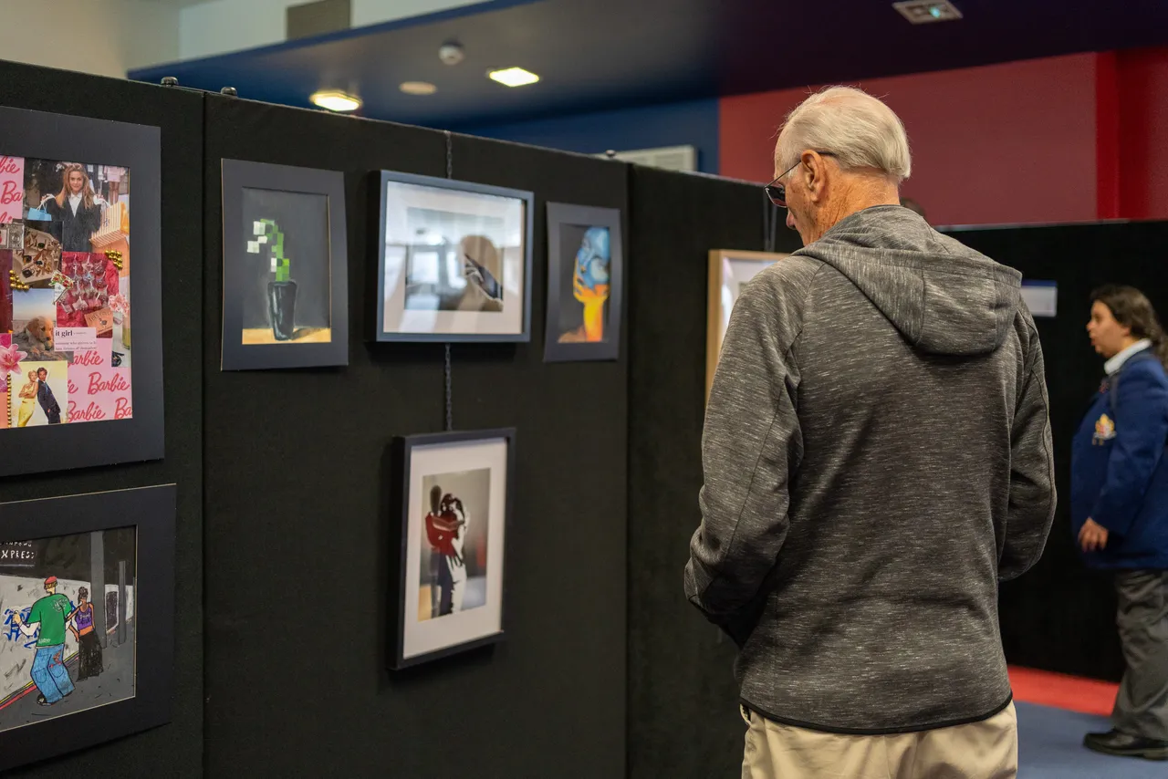 A guest at Overnewton's Annual Visual Arts & Technologies Exhibition viewing photography taken by Senior School Technologies students.