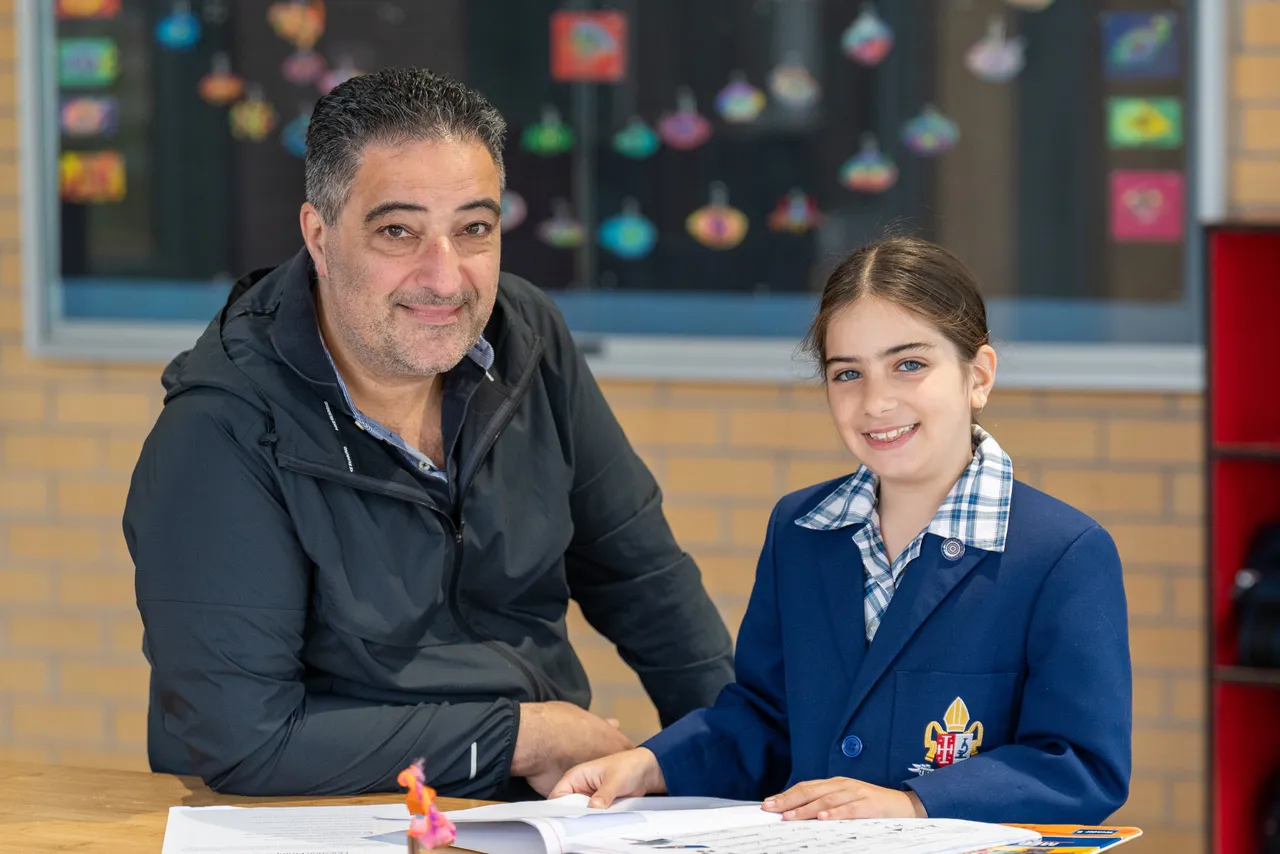 Middle primary school aged student with her father, a guest at Overnewton Junior School during the Celebration of Learning event.