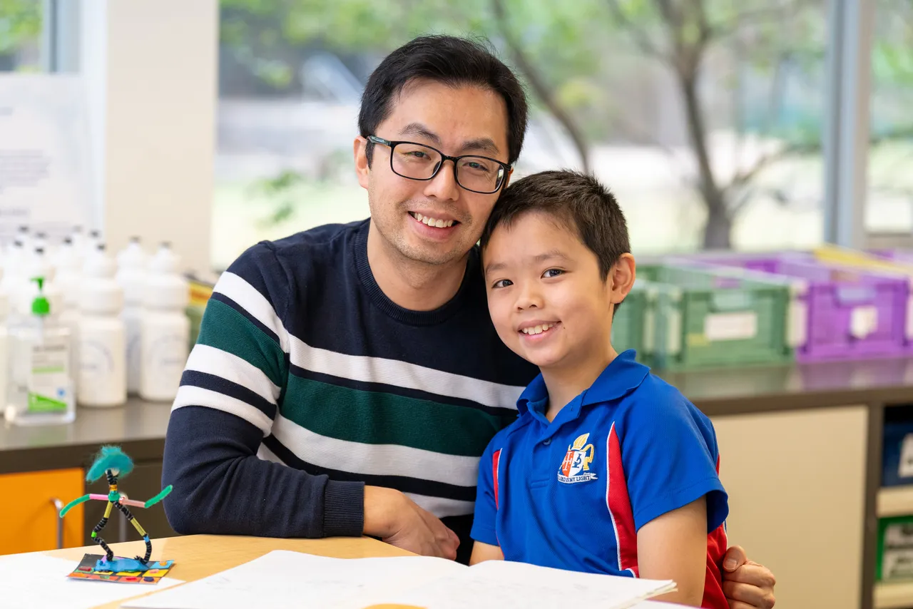 Lower primary school aged student with his father, a guest at Overnewton Junior School during the Celebration of Learning event.