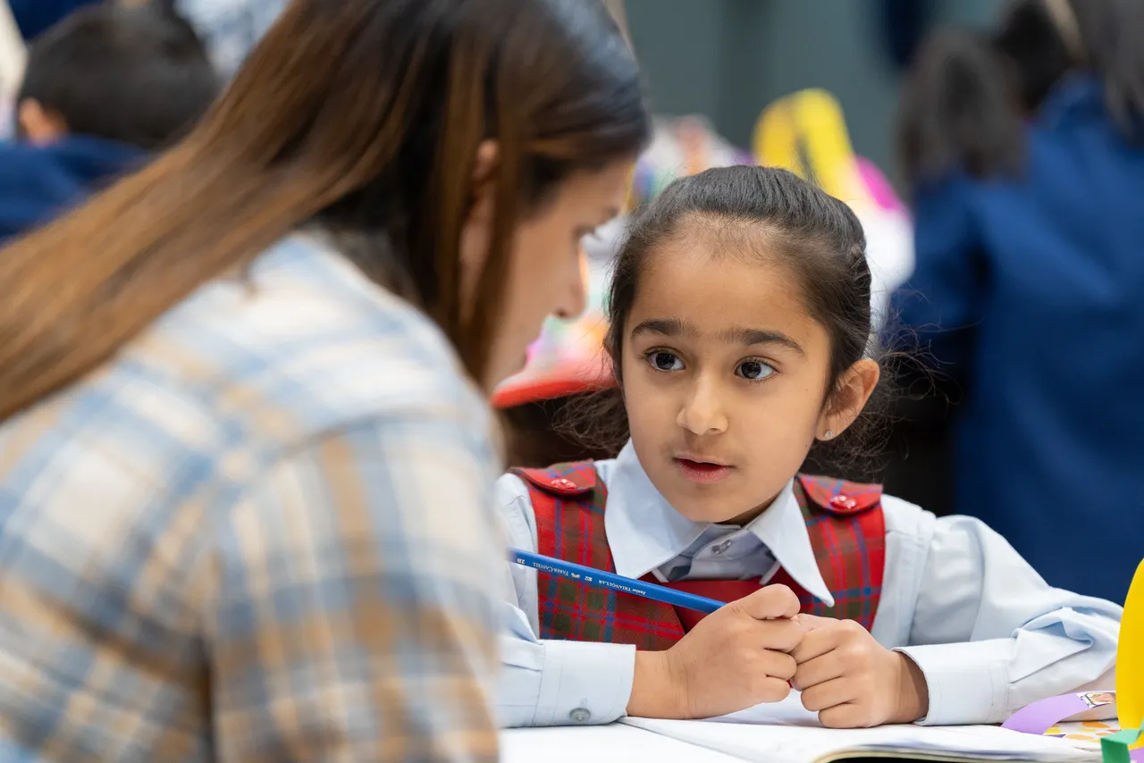 Lower primary school aged student speaking with her mother, a guest at Overnewton Junior School during the Celebration of Learning event.