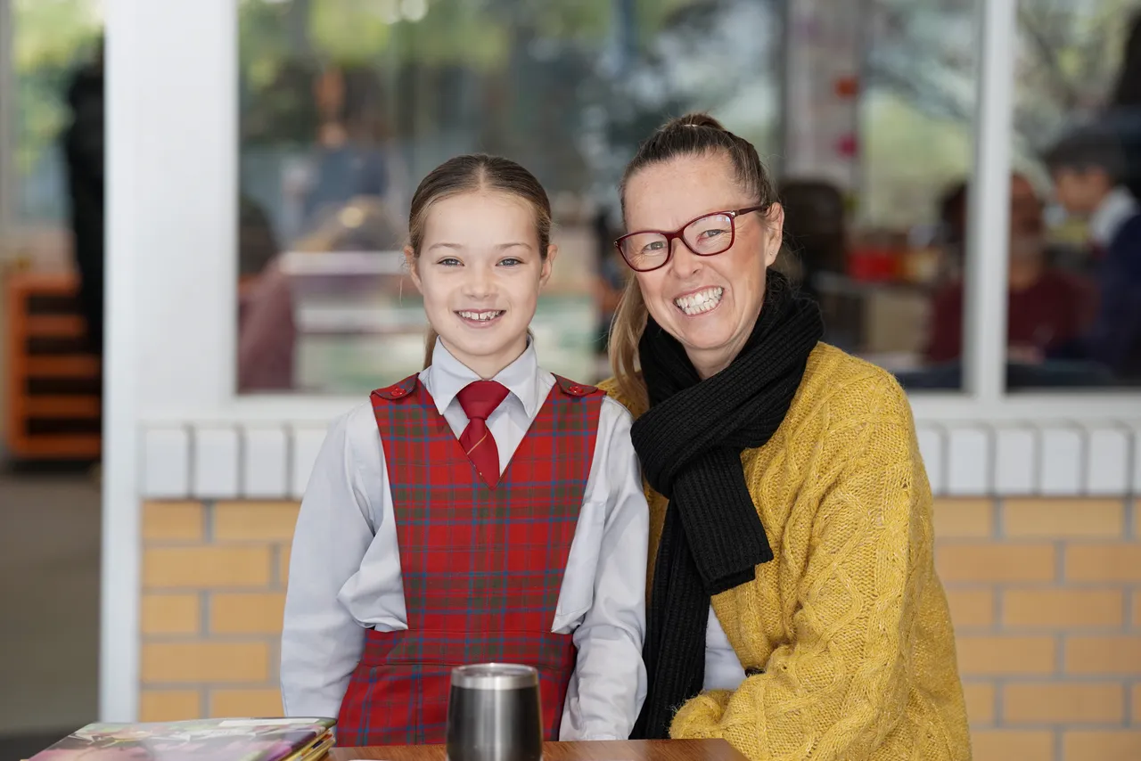 Middle primary school aged student proudly posing with her mother in her classroom during the Junior School's 2026 Celebration of Learning event.