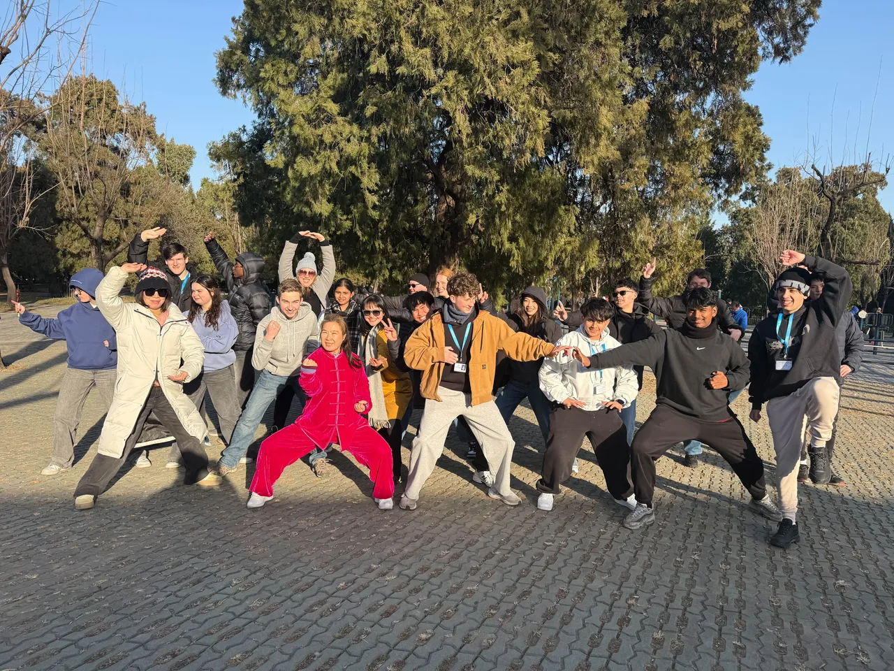 Middle and upper secondary school aged students and staff striking Kung Fu poses with an instructor outdoors during Overnewton’s 2025 China Tour.