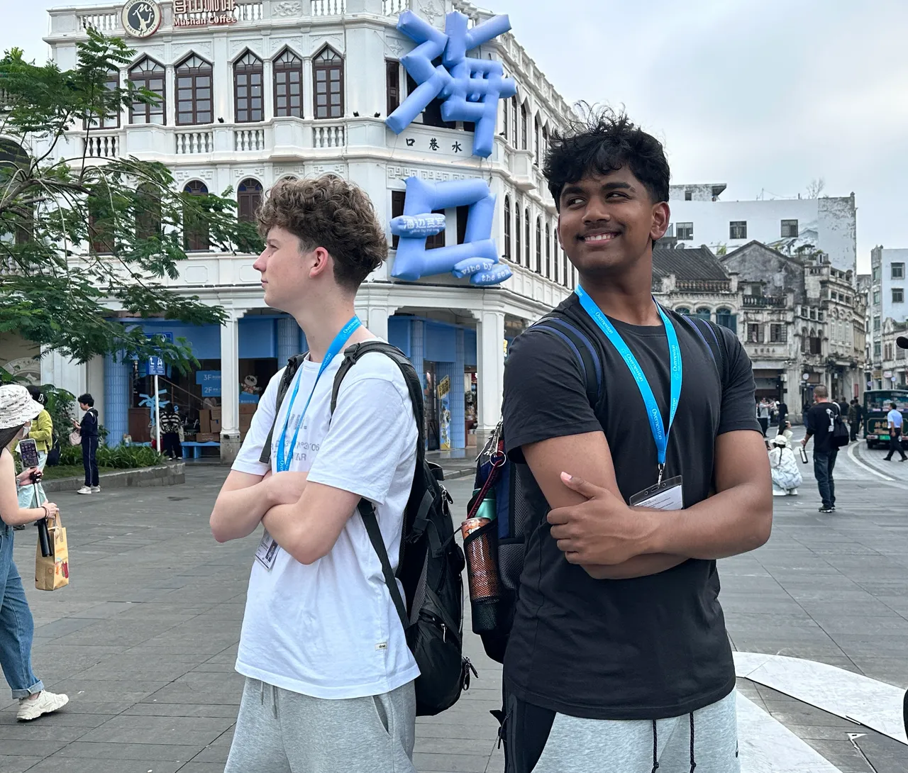 Upper secondary school aged students posing in front of a building in the shopping district of Hainan as part of Overnewton's 2025 educational travel tour to China.