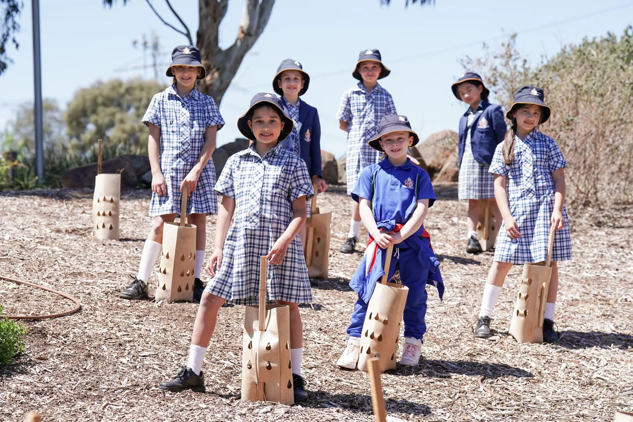 Junior School students at Canowindra Campus who participate in the Waa's Helpers Synergy program proudly standing beside native saplings they planted as part of the 100 Trees Program.