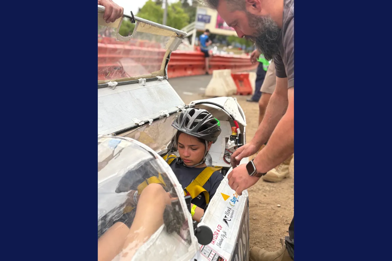 Year 9 Overnewton student driver during a pit stop where a parent works on the competition vehicle at the Energy Breakthrough Challenge in Maryborough.