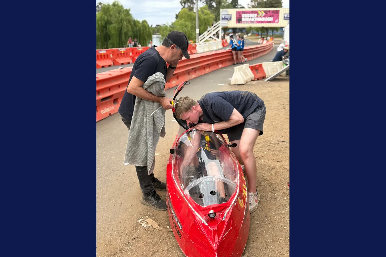 Overnewton Technologies teacher, Ian Moore, and parent assist a Year 9 student with their vehicle as they compete in the Energy Breakthrough Challenge at Maryborough.