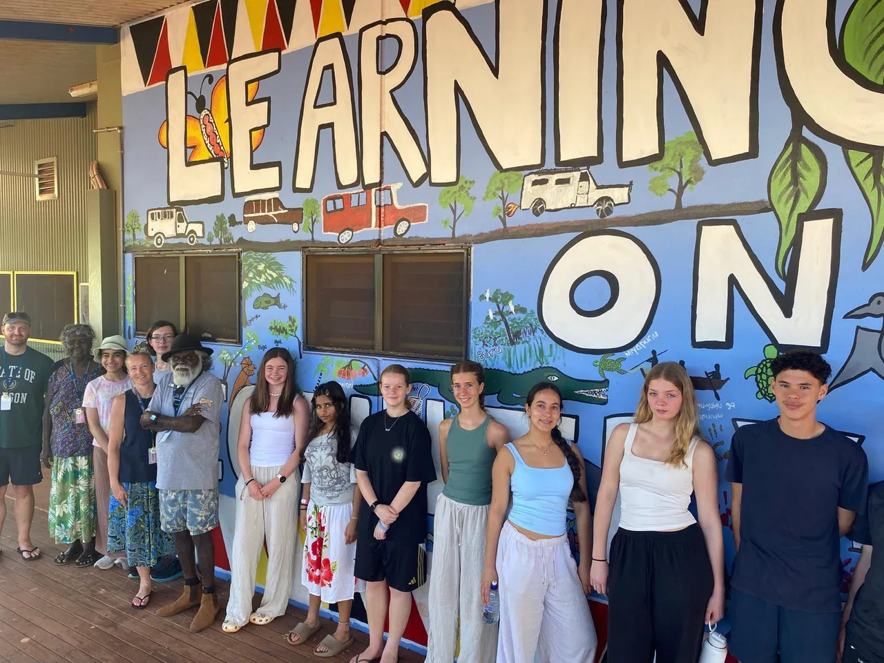 Upper secondary school aged students standing in front of a Learning on Country sign at Shepherdson College on Elder at Elcho Island in the Northern Territory during Overnewton’s 2025 Galiwin’ku educational travel program.