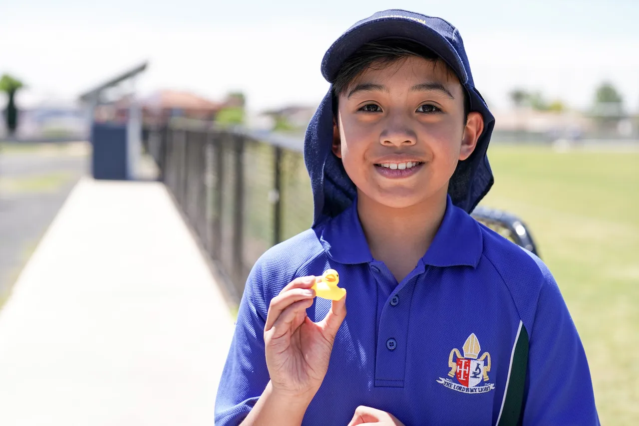 Middle primary school aged student from Overnewton Junior School proudly showing the miniature duck he found during the "Duck Hunt" activity at Canowindra Campus during House Activate Day.
